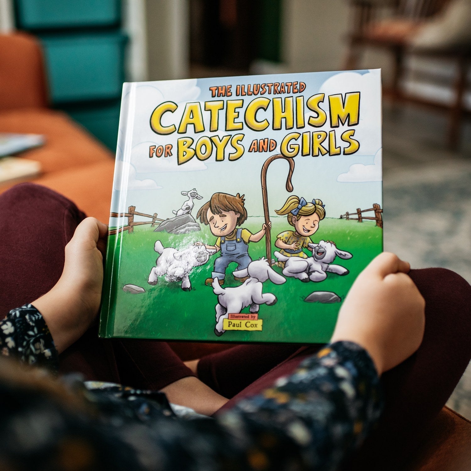 Young girl's hands holding copy of The illustrated catechism for boys and girls