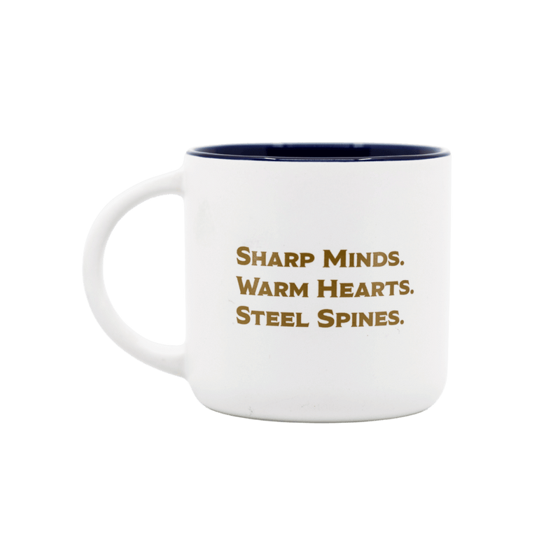 A white ceramic coffee mug with a dark navy blue interior and gold text that reads 'SHARP MINDS. WARM HEARTS. STEEL SPINES'