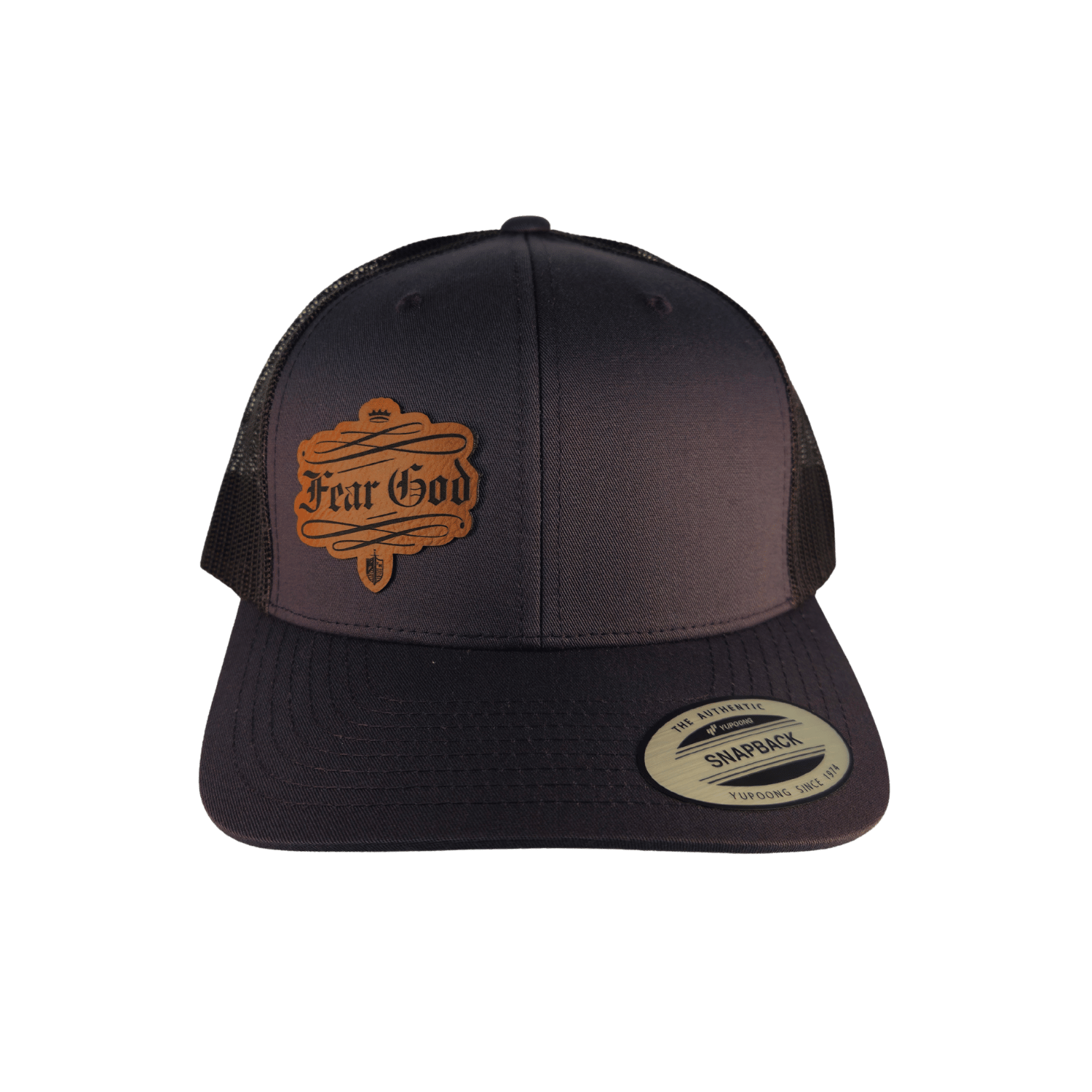 A black trucker hat with a brown leather patch on the front that reads 'Fear God' in gothic lettering. The back of the cap is made of black mesh. [Smoke]