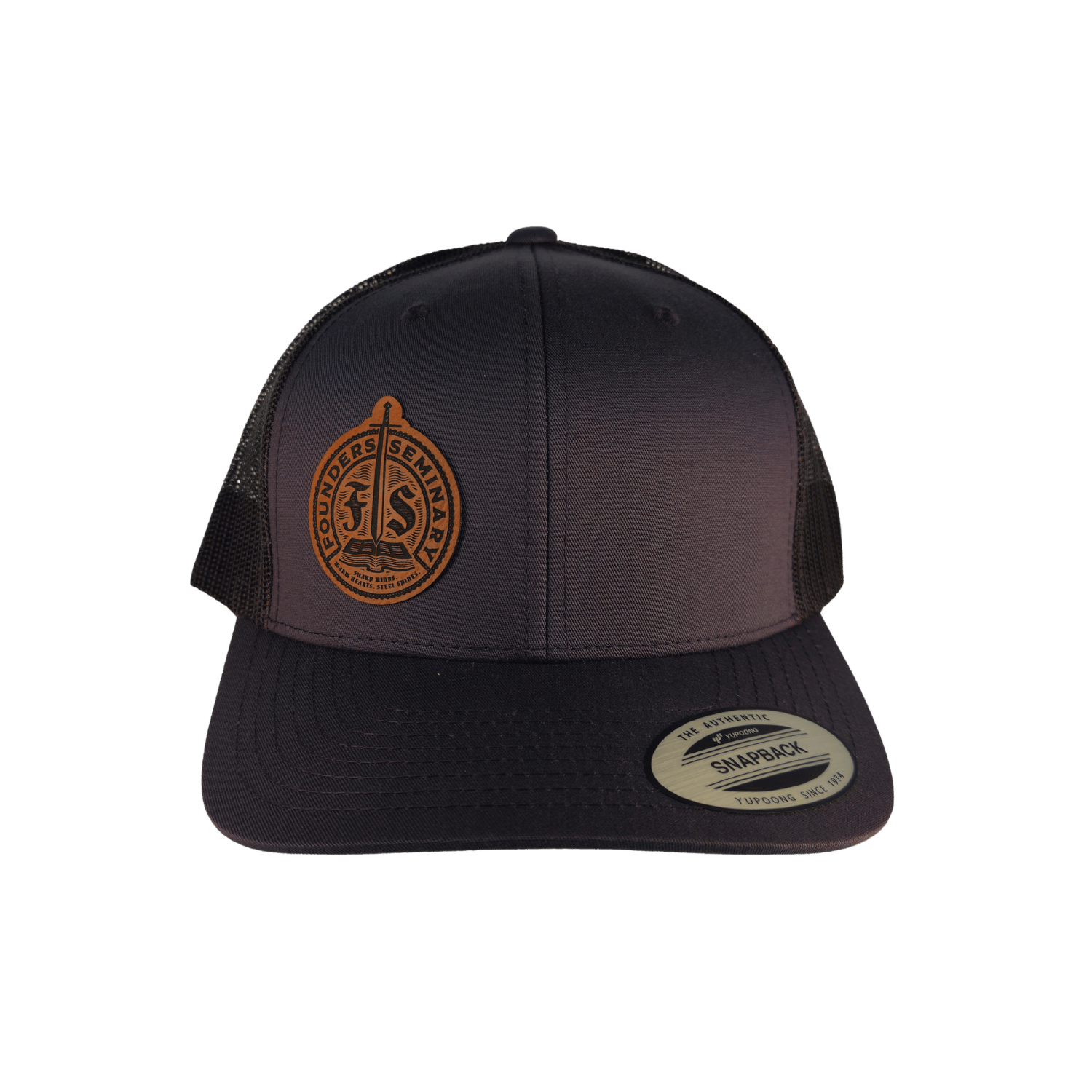 A dark charcoal trucker hat with a brown leather patch on the front 