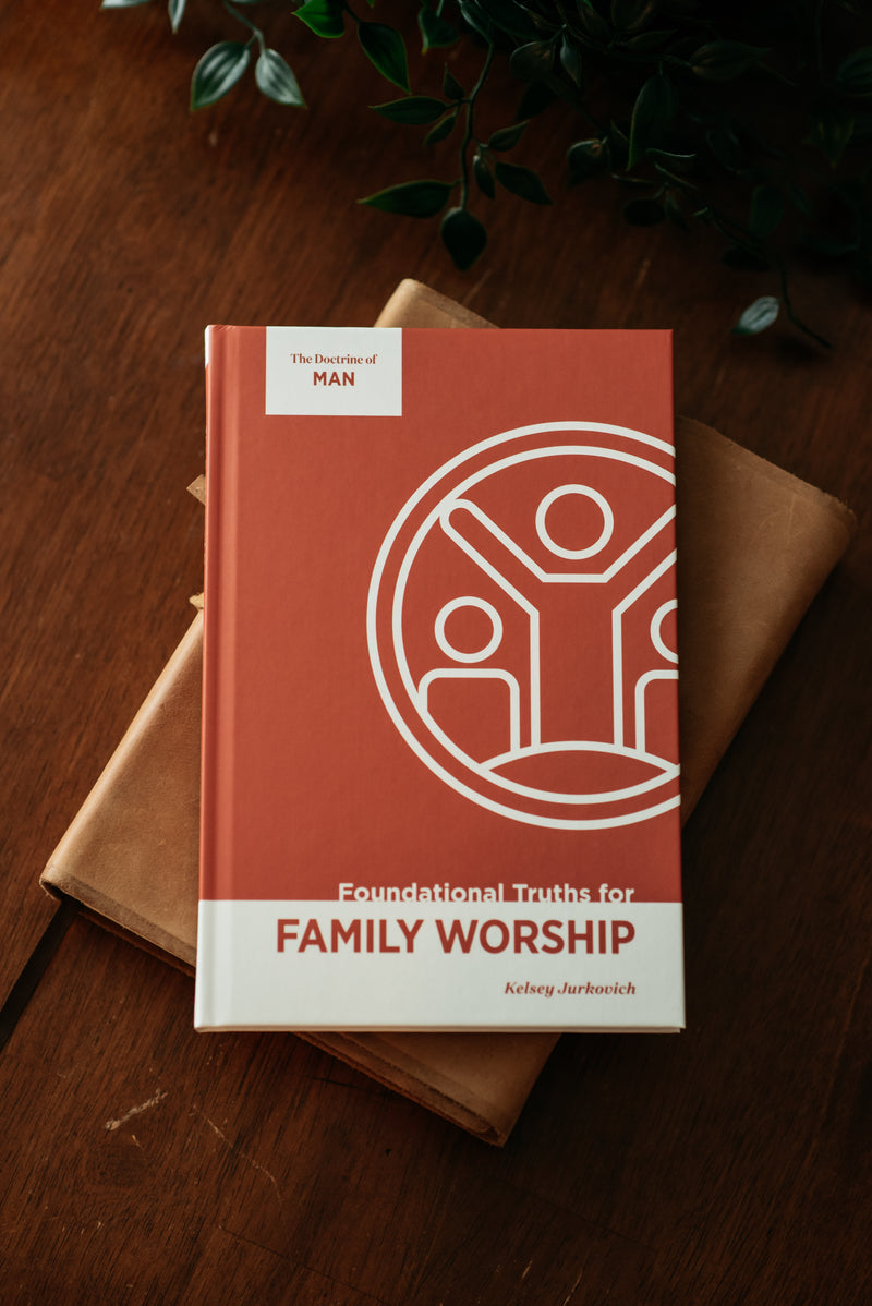 Book titled 'Foundational Truths for Family Worship' on a wooden surface with a plant in the background