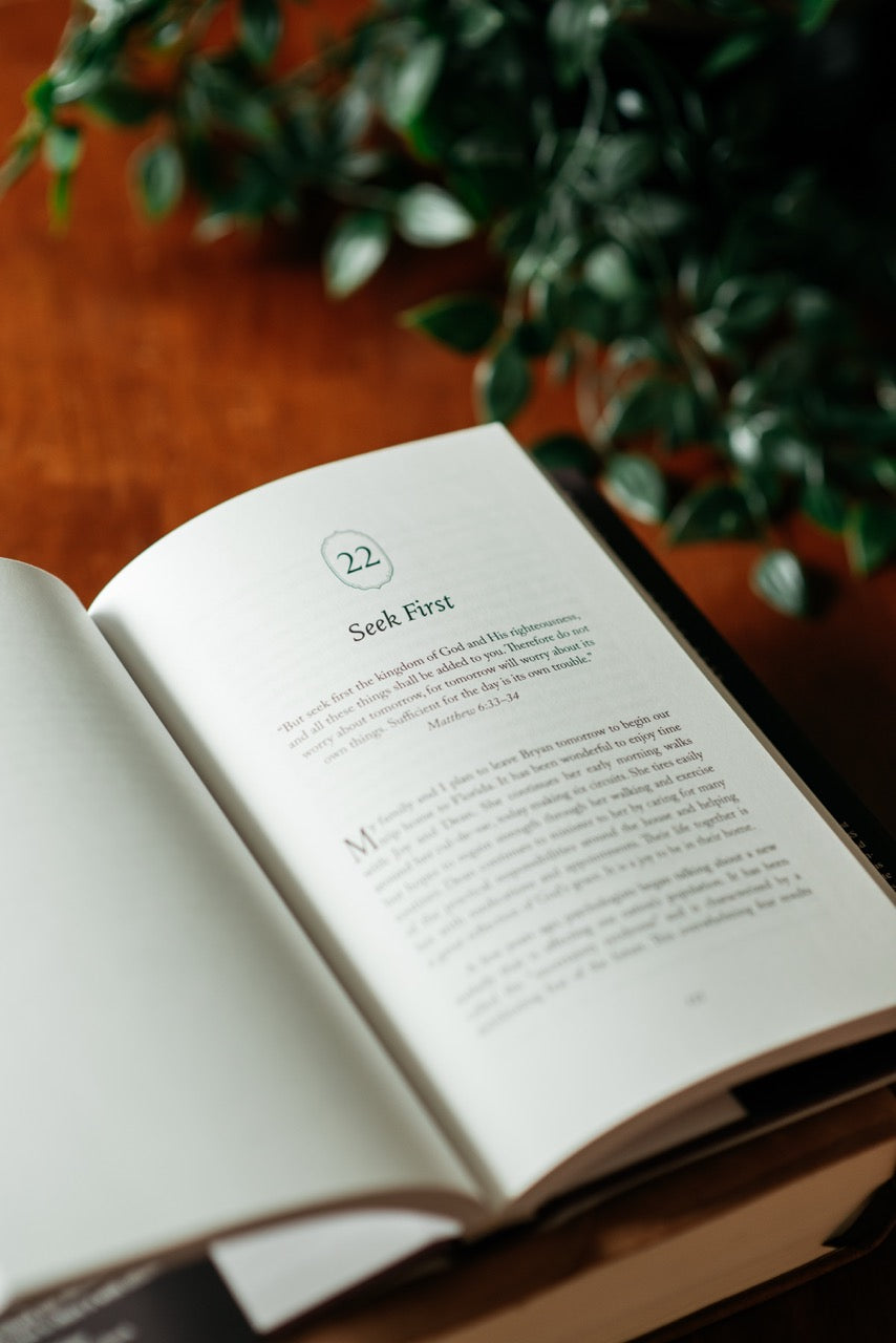 Suffering with Joy Book interior page on Wood table with plant