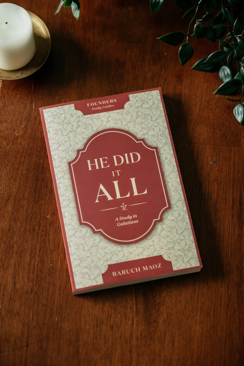He Did It All Book on wood table with plant and candle. 