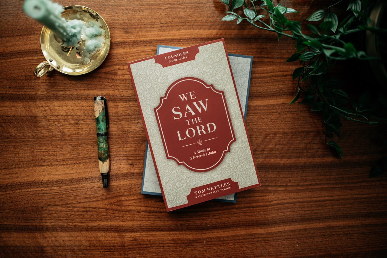 We Saw the Lord book on wood table with plant and candle. 