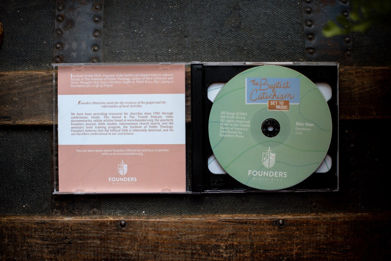 Baptist Catechism CD opened on a wood table