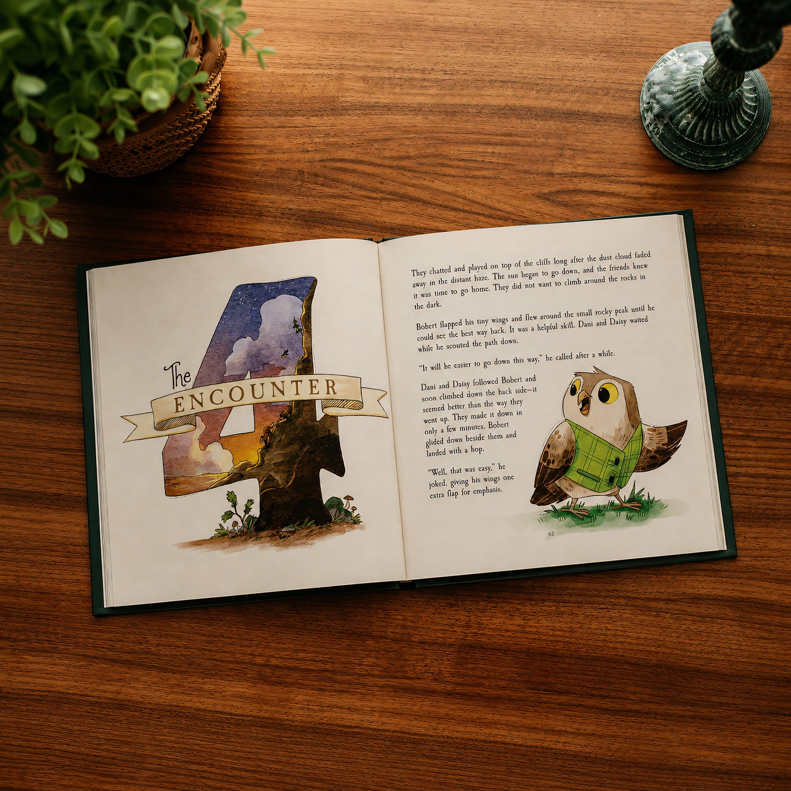 An open children's book titled 'The Encounter' lies on a wooden table, showing illustrated pages with a large number 4 made from trees and a green-clad owl. A potted plant and a decorative lamp are partially visible around it.