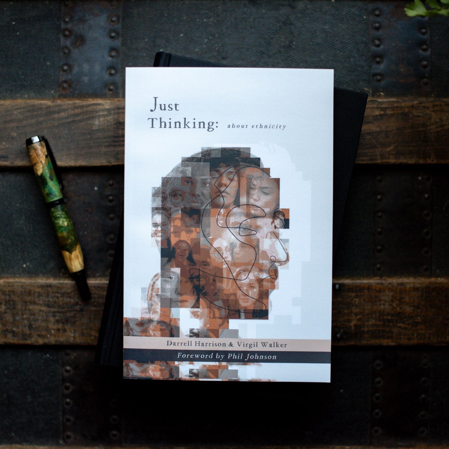 Book titled 'Just Thinking' on a textured surface with a pen beside it