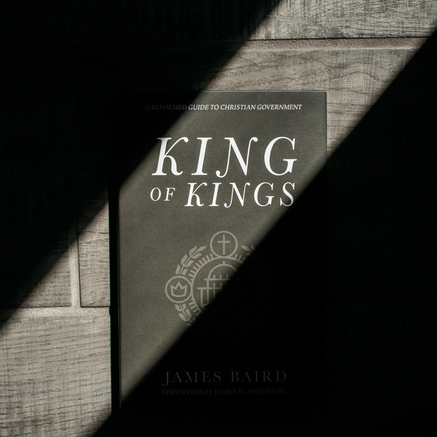 Book titled 'King of Kings' by James Baird on a wooden surface with a black and white color scheme.
