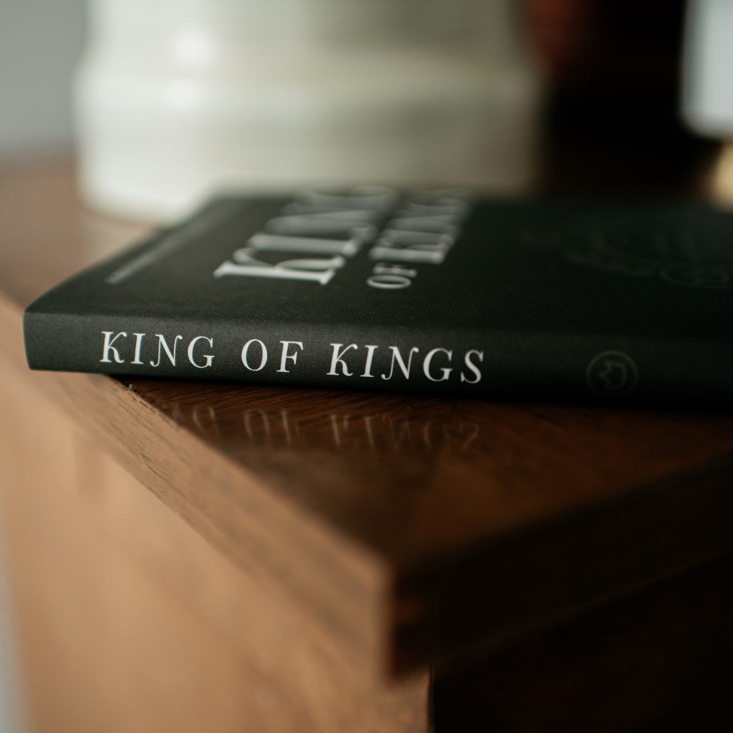 Book titled 'King of Kings' on a wooden surface with a blurred background