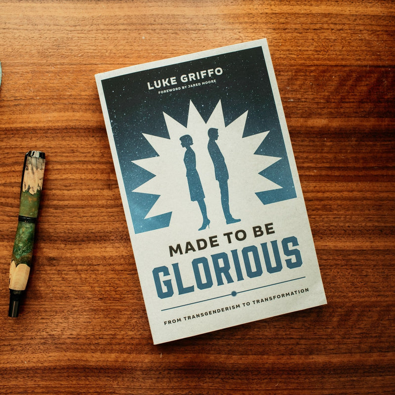 Book titled 'Made to be Glorious' by Luke Griffo on a wooden surface with a pen.