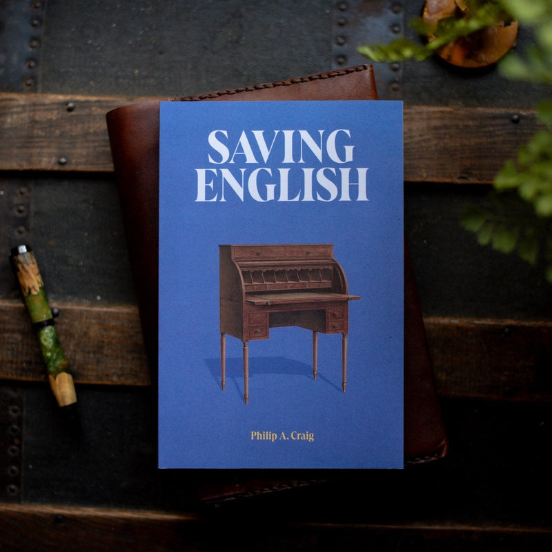 Book titled 'Saving English' by Philip A. Craig on a wooden surface with a blue cover.