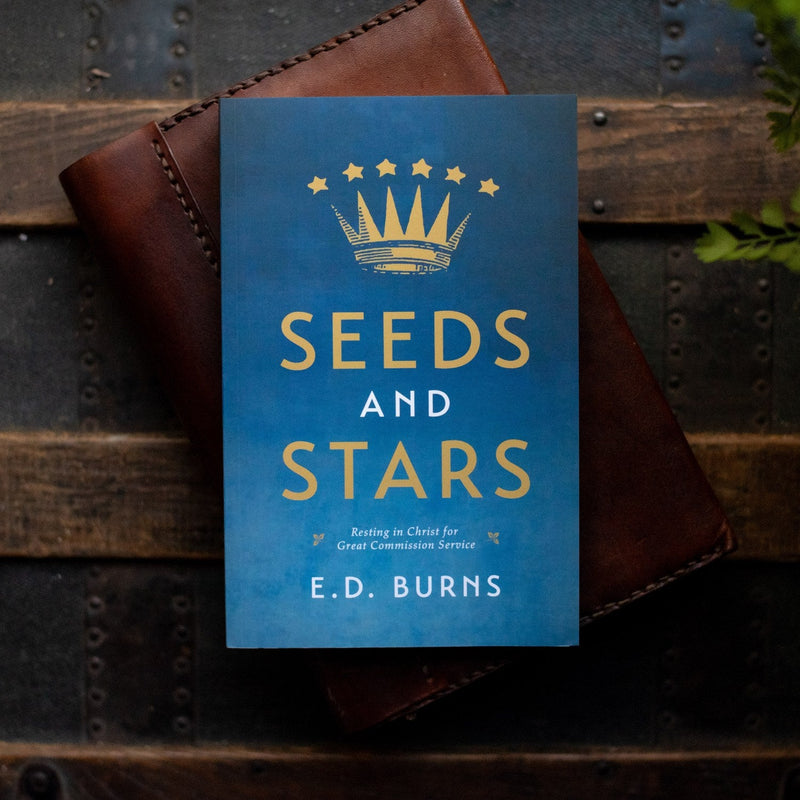 Book titled 'Seeds and Stars' by E.D. Burns on a wooden surface