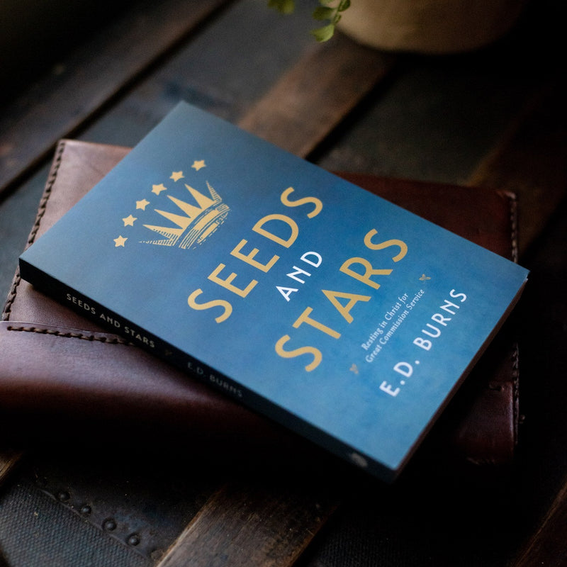 Book titled 'Seeds and Stars' by E.D. Burns on a wooden surface