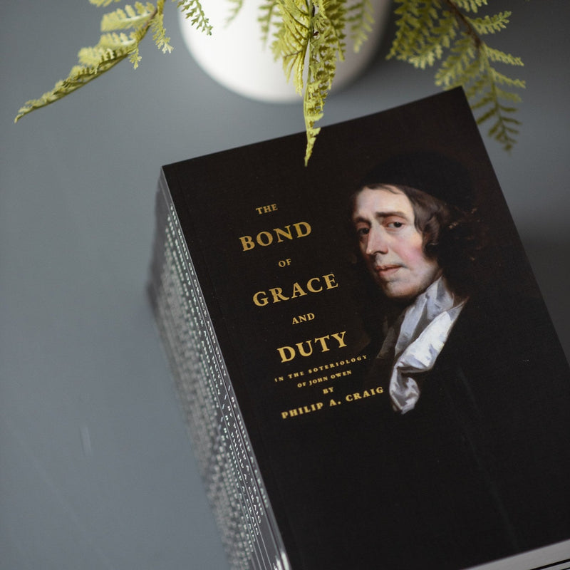 Book titled 'The Bond of Grace and Duty' by Philip A. Craig with a portrait on the cover, placed on a textured surface with green leaves in the background.